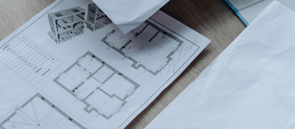 Rzuty domu i dokumentacja projektowa na biurku